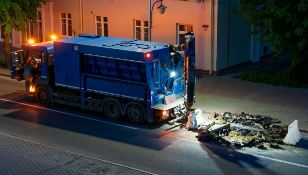 Team Road Builders Perform Road Repairs Night With Help Large Truck Vacuum Cleaner Professional Repairmen Change Manhole Roadway 1